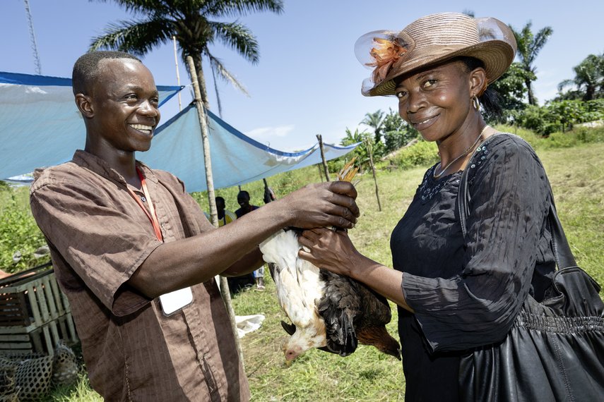 Eine Frau und ein Mann halten ein Huhn in der Luft