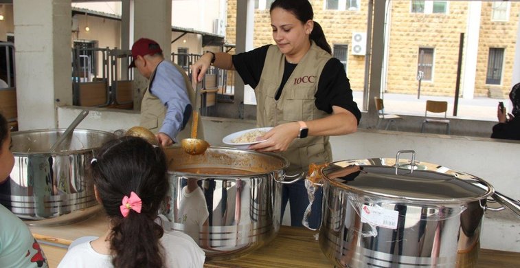 Kinder bekommen Suppe ausgeteilt. 