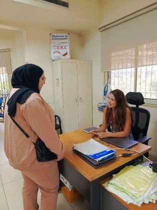 Die Palästinenserin Amal spricht mit einer Mitarbeitenden im Gesundheitszentrum