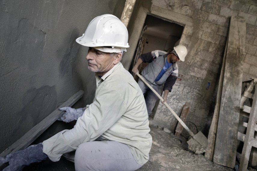 Bauarbeiter verputzt eine Wand 