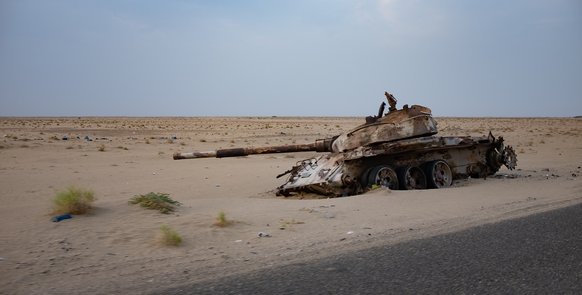 Panzer liegt im Graben einer sandigen Landschaft