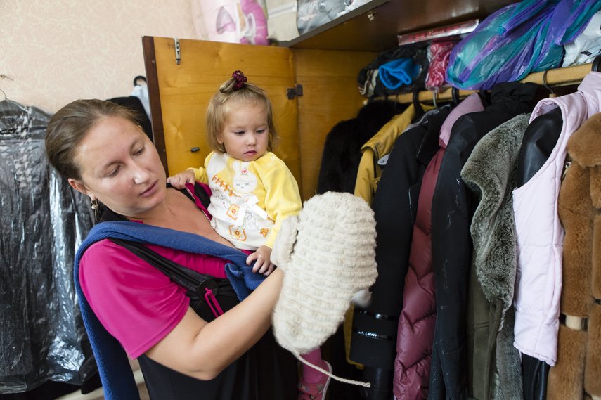 Frau mit Kind vor Kleiderschrank