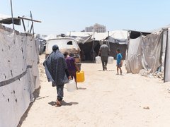 Menschen tragen Wasser in ihre Unterkunft