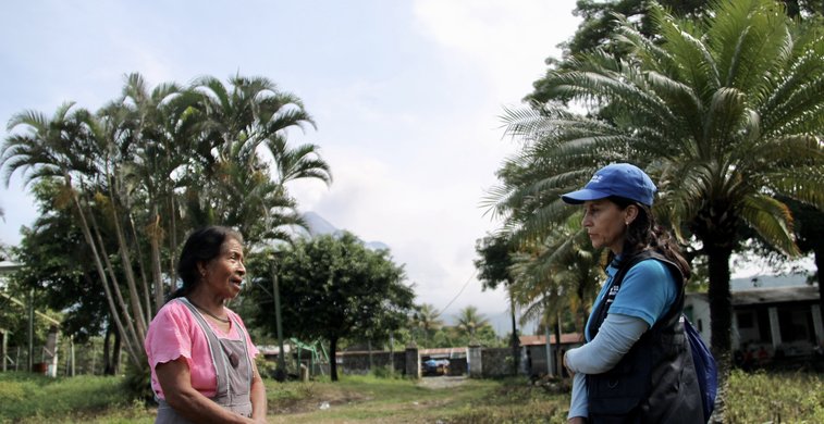Zwei Frauen unterhalten sich vor Palmen in Guatemala.
