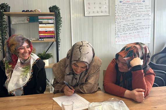 Frauen sitzen an einem Tisch und füllen eine Liste aus