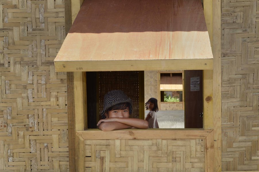 Kind lehnt auf Holzfenster