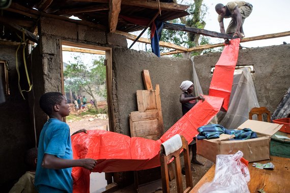 Eine Familie dichtet mit Plastikplanen, die sie bei einer Nothilfe-Verteilung durch die Diakonie Katastrophenhilfe, Finn Church Aid und Lutherischer Weltbund in Saut-Maturin 2eme Section unweit von Camp Perrin am 14.10.16 bekommt hat, das zerstoerte Dach ihres Hauses ab. Jeweils 175 Hygiene, Essen- und Notfallkits mit Plastikplanen, Decken und Seilen werden an vorher ausgesuchte und registrierte Betroffen verteilt. UN-Blauhelm-Soldaten schuetzten die Verteilung. Am Ende der Verteilung, wenn die letzten Pakete verteilt werden, wird die Situation auf schwierig. Foto: Thomas Lohnes fuer Diakonie KatastrophenhilfeAfter the storm clean drinking water is scarce. The people have to be supplied with clean drinking water and the sanitation has to be repaired. Wells and toilets were destroyed by the hurricane Matthew. The water is polluted and there is a great danger that diseases such as cholera can break out. First cholera cases have been reported. Matthew had heavily devastated the southern half of Haiti on Tuesday last week. According to preliminary information from the authorities, 372 people were killed. Some regions are still cut off from the rest of the country. In some cities 80 per cent of the houses are destroyed or damaged, according to aid organizations.