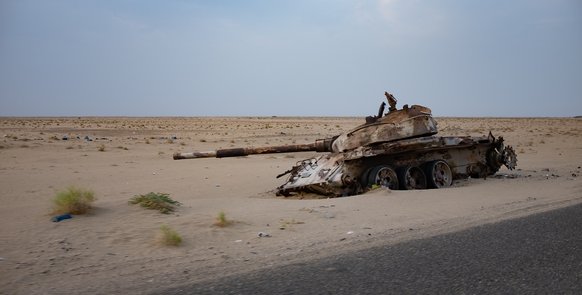 Panzer liegt im Graben einer sandigen Landschaft