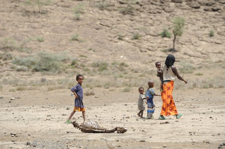 Eine Mutter mit Kindern läuft durch eine vertrocknete Landschaft in Äthiopien.