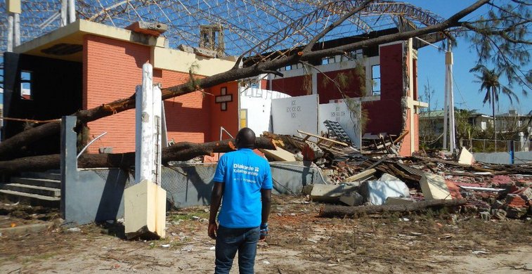 Mann vor zerstörtem Haus in Mosambik