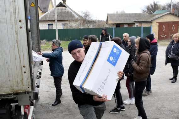 Ein Mann räumt Kartons aus einem Lastwagen mit Hilfslieferungen.