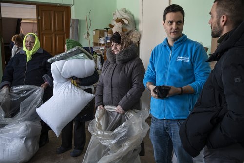 Pragrammkoordinator Mario Göb spricht mit Helfern während der Verteilung von Winterhilfe