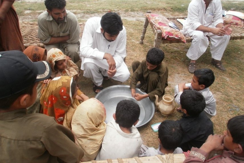 Männer und Kinder sitzen in Pakistan im Kreis