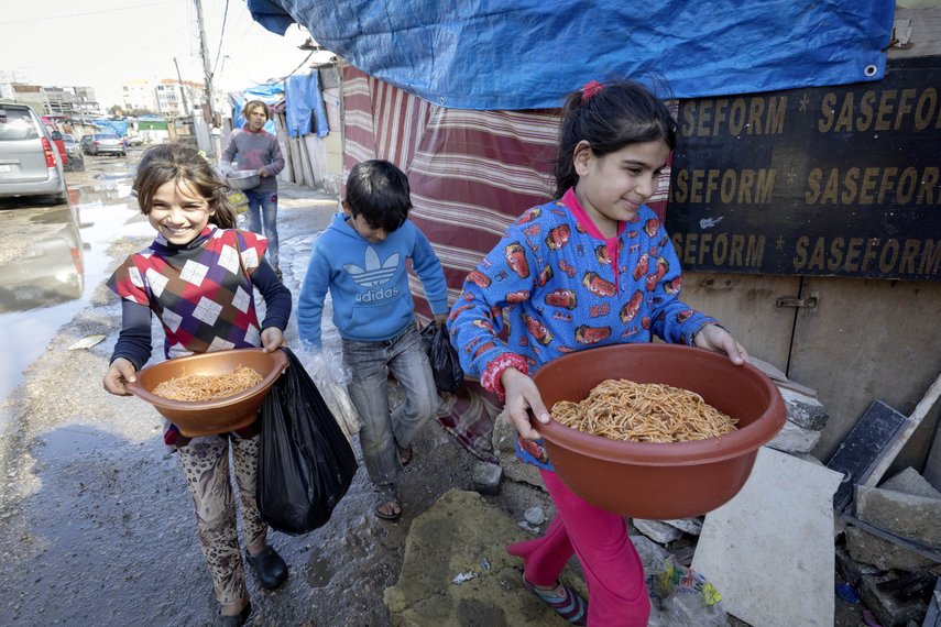 Kinder in Jordanien tragen Schüsseln mit warmen Speisen